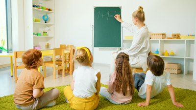 Foto mit Kinder und Betreuungsperson von hinten